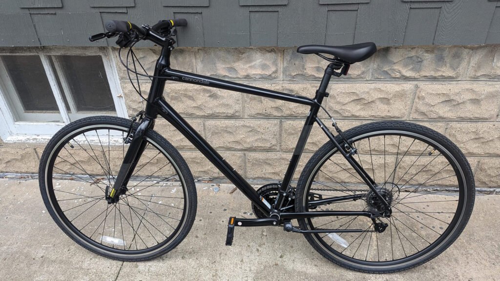 All black bicycle with a mountain bike style frame, and gravel/commuter tires.